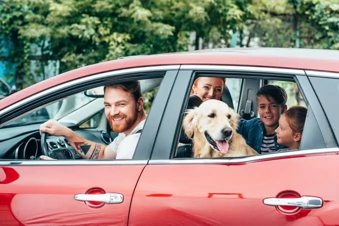 Familia viajando en su auto con su perro