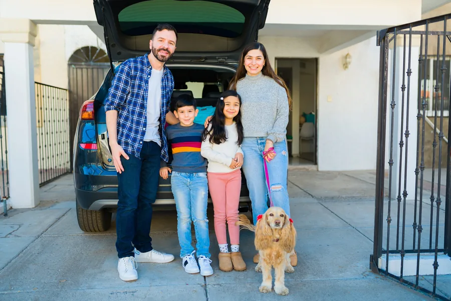 Familia junto a su hogar y su mascota