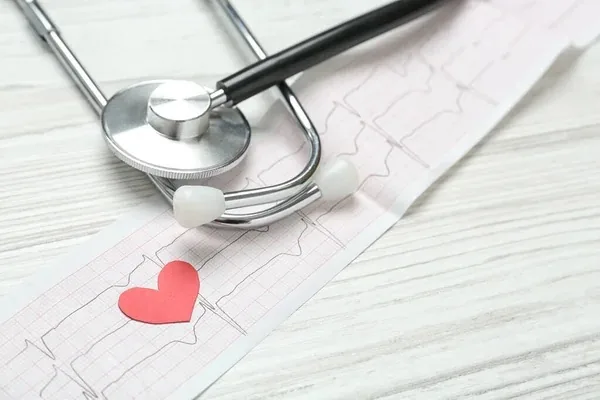 Estetoscopio y corazón sobre un informe médico